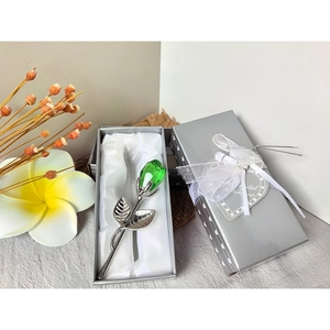 Green crystal rose in a silver gift box with white satin lining and lace bow decoration