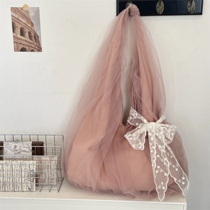 Détail d'un sac cabas en tulle rose orné d'un magnifique nœud en dentelle blanche