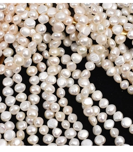 Macro shot of 9-10mm baroque freshwater pearls with creamy luster on a black background