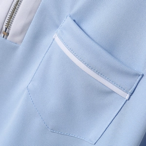 Detail of piqué fabric texture featuring a light blue pocket with a zipper and white trim