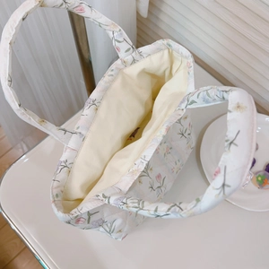 Detail of floral quilted cotton tote bag with spacious open interior and soft lining