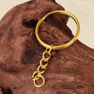 Polished 18K gold-plated 304 stainless steel key ring with chain on a wood surface