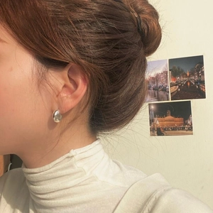 Close-up of minimalist S925 sterling silver curved crossover stud earrings on model