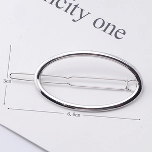 Minimalist silver oval metal hair clip showing 6.6cm length dimension on white card