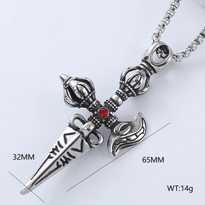 Macro detail of a vintage stainless steel vajra pendant necklace with a red center stone