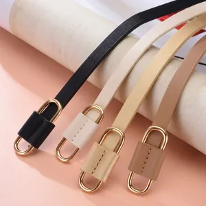 Detail von vier dünnen Ledergürteln in Schwarz, Beige, Gold und Braun mit Goldschnalle