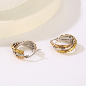 Detailed view of textured tricolor intertwined hoop earrings in gold, silver, and rose gold