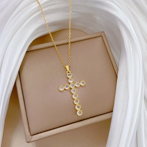 Detailed view of a gold cross pendant necklace featuring brilliant round-cut pavé zircons
