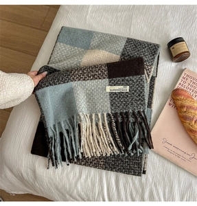 Close-up of soft plaid scarf with tassels, fringe details and premium woven texture