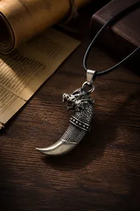 Dettaglio di un ciondolo a dente di drago in bronzo vintage con trame a scaglie