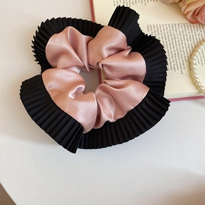 Détail d'un chouchou en satin rose et mousseline plissée noire au style rétro français