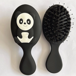 Detail view of small black panda cartoon hairbrush showing bristle and cushion sides