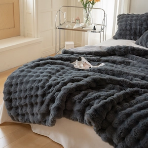 Detail of dark grey faux fur blanket with 3D wave embossing and soft plush texture
