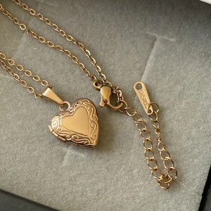 Detailed macro of a gold heart-shaped locket necklace in a velvet jewelry box