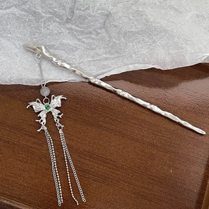 Close-up of silver tassel hair pin with bamboo texture and green stone butterfly detail