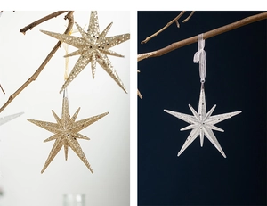 Detail of champagne gold and silver acrylic star ornaments with shimmering glitter texture