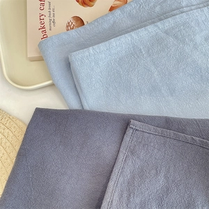 Detail view showing the textured fabric and neat stitching of solid color placemats.