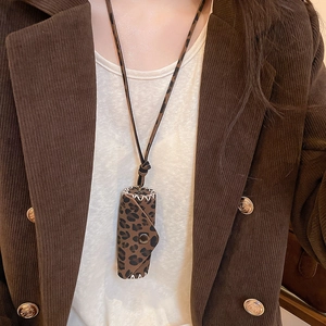 Close-up of leopard print leather lipstick pouch necklace with bronze snap and stitching