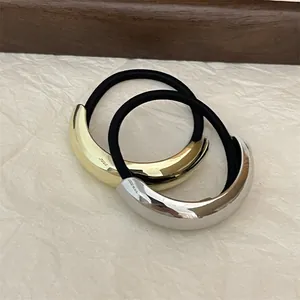 Close-up of sleek gold and silver curved alloy hair ties with S925 engraved details