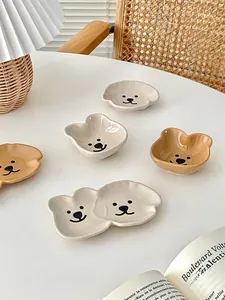 Detailed view of cute bear and dog ceramic sauce dishes in a cozy home setting