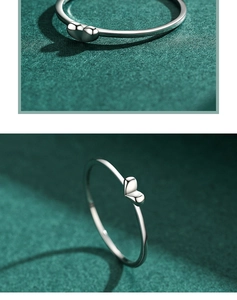 Detailed macro view of S925 silver minimalist heart ring on dark green background