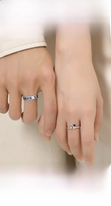 Close-up of astronaut couple rings with blue enamel galaxy and star pendant detail