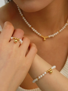 Détail de la parure en perles d'eau douce avec billes dorées et pendentifs sphères