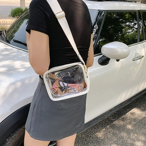Detailed side view of clear PVC crossbody bag with white leather trim and wide strap