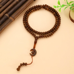 Macro view of 99-bead Tasbih prayer beads with star and moon charm and silk tassel