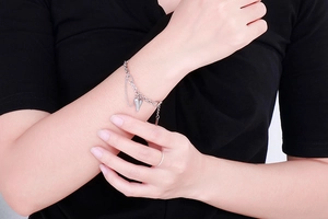 Close-up of a silver heart pendant bracelet on wrist with adjustable chain detail