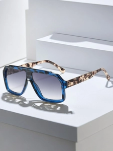 Detail of square blue tortoise shell sunglasses on a white geometric platform