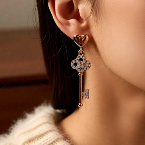 Macro close-up of 18k gold plated heart key earrings with sparkling pave zircon stones