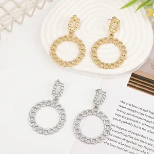 Detail of gold and silver chain textured geometric earrings on a white display tray