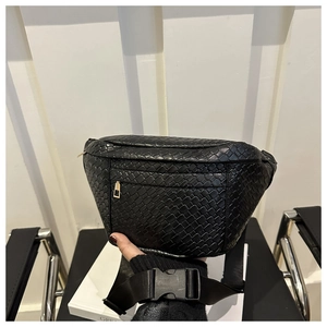 Detailed macro view of black woven waist bag with metallic zipper and nylon strap