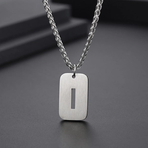 Vue macro du pendentif rectangulaire argenté avec texture brossée et chaîne de collier