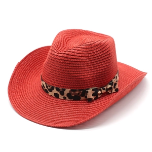 Detail of red straw cowboy hat featuring leopard print ribbon and side bow decoration