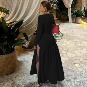Détail de la robe noire à manches longues avec fente latérale haute et coupe ajustée