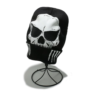 Winter knitted beanie with large white skull print design for men in black street style