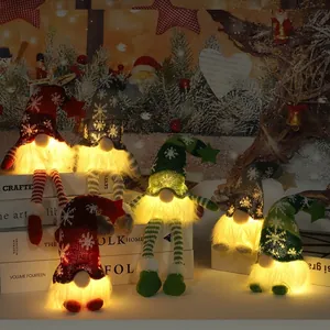 Tre gnomi di Natale luminosi con cappelli a fiocco di neve e luci LED calde in posa