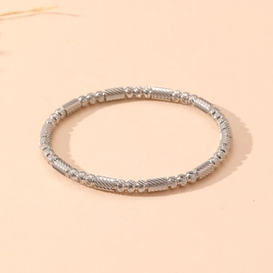 Detailed macro view of silver beaded bracelet with textured cylinders and smooth beads