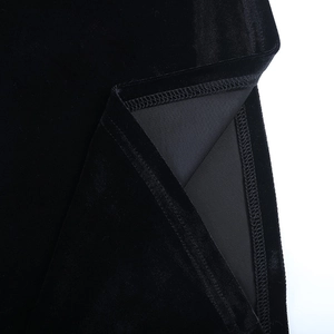 Gros plan de l'ourlet d'une robe en velours montrant les coutures doubles et le tissu premium