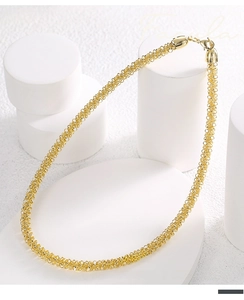 Macro shot of gold-plated woven mesh collar necklace with detailed texture and lobster clasp