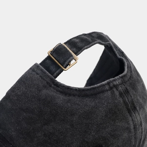 Detail der verwaschenen Denim-Basecap mit verstellbarem Riemen und bronzener Schnalle