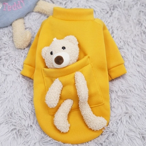 Yellow pet hoodie with 3D teddy bear in pocket on plush carpet, warm dog sweater