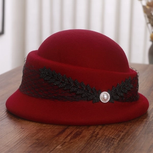 Détail du béret en laine bordeaux avec dentelle noire, feuilles à paillettes et perle