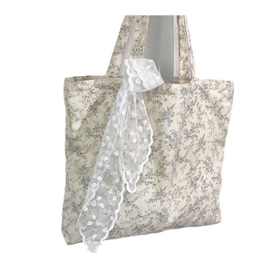 Floral canvas tote bag with elegant lace trim and blue flower patterns on white background