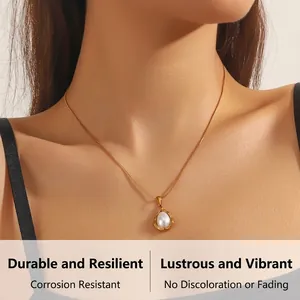Close-up of gold tone teardrop necklace with pearl pendant worn on a model's collarbone