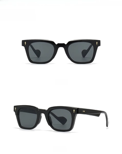 Detail of black cat-eye sunglasses featuring golden arrow accents on the temples