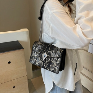 Chic snakeskin print chain shoulder bag with diamond buckle worn by a model