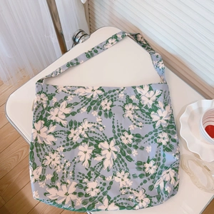 Vista piatta della borsa tote in tela floreale lavanda con stampa di fiori bianchi e luce soft